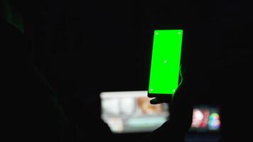 Zoom in shot of man holsing a smartphone with green screen mock-up on it video