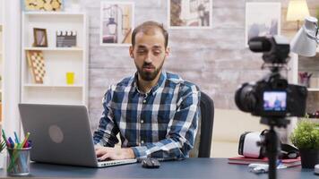 Famous influencer typing on computer while recording a podcast. Creative content creator. video