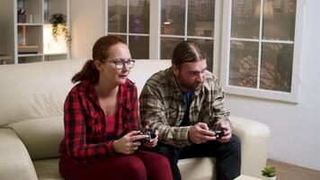 alegre joven Pareja celebrando su victoria mientras jugando vídeo juegos. emocionado Pareja dando alto cinco. video