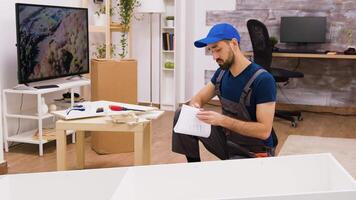 Jeune Masculin ouvrier Assemblée détails de meubles dans Nouveau maison, outils pour meubles assemblée. video