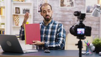 famoso jovem vlogger gravação uma Reveja do uma livro para assinantes. vlogger estilo de vida. video