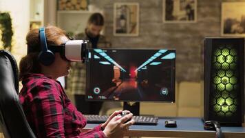 Professional female gamer using vr headset and wireless controller to play computer games. Man texting on phone in the background. video