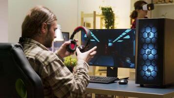 Man keeping his head on desk after losing at video games on computer. Game over for male gamer.