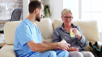 Senior woman in nursing home talking with male doctor while taking her medicamentation video