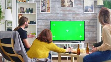 indietro Visualizza di vicino amici applauso mentre Guardando un' calcio campionato su tv con verde schermo. video