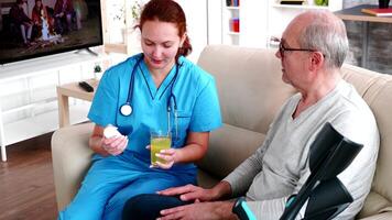 Doctor in nursing home giving old man pills for his illness. video