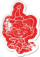 quirky cartoon distressed sticker of a dog kicking wearing santa hat png