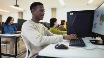 a young man is sitting at a desk with a computer video