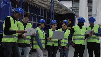 a group of multiracial engineers in hard hats and vests working in robotic factory video