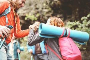 Happy team friends doing trekking excursion on mountains - Group young tourists hiking and exploring the wild nature - Trekker, hike sport and travel people concept photo