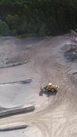 Vertical Video of Bulldozer in Action in Open Air Quarry