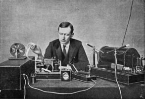 Marconi in front of his receiving device for wireless telegraphy, vintage engraving. photo