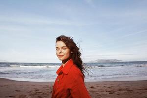 Smiling Woman by the Sea. Embracing Freedom and Joy in Red Beach Clothes photo