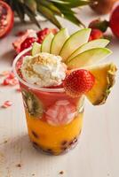 lebanese cocktails include pineapple, kiwi, strawberry, mango, pomegranate fruit slice served in glass isolated on table top view of healthy morning drink photo