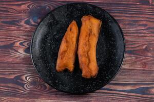 deep fried brinjal pakora or beguni served in a dish isolated on background top view of Indian and bengali food photo