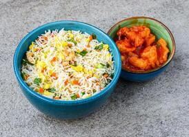 Egg fried rice with sweet and sour chicken served in bowl isolated on background top view of asian food photo