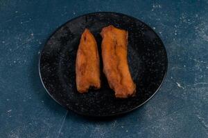 deep fried brinjal pakora or beguni served in a dish isolated on background top view of Indian and bengali food photo