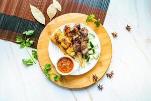 Satay Skewer Sticker with sauce served in dish isolated on wooden board top view on marble background hong kong food photo