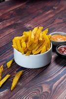 Crispy French Fries or potato chips with mayo dip and tomato sauce served in a plate side view view photo