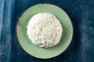 Plain boiled rice in a plate top view on marble background photo