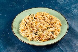 Traditional Spicy chow mein in a bowl isolated on marble background top view of chinese noodles photo