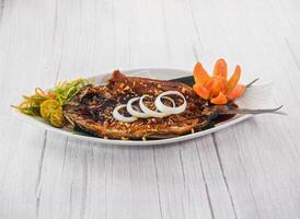 Bangus Bistek with onin rings served in dish isolated on grey wooden background side view of fastfood photo