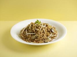 stewed ee-mian noodles with Dried Shrimps served in a dish isolated on cutting board side view on dark background photo