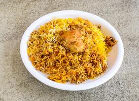 Spicy chicken biryani rice served in plate isolated on grey background top view of pakistani and indian spices food photo