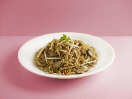 Stewed Ee-Fu Noodles with Assorted Seafood served in a dish isolated on cutting board side view on dark background photo