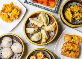 pan fried guotie dumpling, osmanthus jelly with wolfberries, fried prawn dumplings, Steamed coriander dumplings, shrimp bean curd rolls, steamed crystal bun, minced pork, shrimp served on food table photo