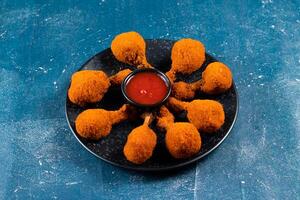 Deep fried Chicken Lolipop or Chicken drumstick with tomato sauce and mayo dip served in a dish isolated on background side view photo