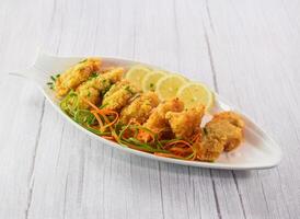 Fish Fillet with lime served in dish isolated on grey wooden background side view of fastfood photo