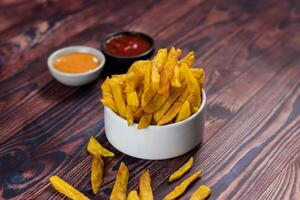 Crispy French Fries or potato chips with mayo dip and tomato sauce served in a plate side view view photo