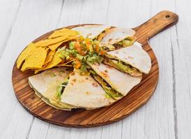 Pizza dillas and nachos served in cutting board isolated on grey wooden background side view of fastfood photo