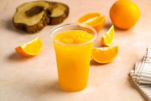 Fresco naranja jugo con crudo Fruta rebanada servido en vaso aislado en mesa parte superior ver sano Mañana bebida foto