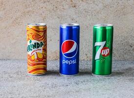 Assorted soft drinks can with 7up, pepsi and mirinda isolated on background top view cold drinks photo