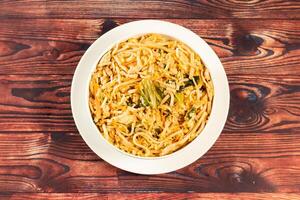 Traditional Spicy chow mein in a bowl isolated on marble background top view of chinese noodles photo