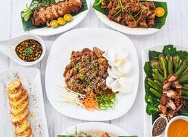 Assorted Philippines food Beef Bulgogi, Chicken Cordon bleu, Crispy Bagnet, Bagnet Kare-kare, lime and sauce served in dish isolated on grey wooden background side view of fastfood photo