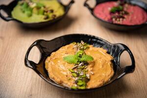 Mix assorted hummus plate served in dish isolated on table top view of arabian food photo