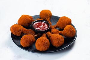 Deep fried Chicken Lolipop or Chicken drumstick with tomato sauce and mayo dip served in a dish isolated on background side view photo