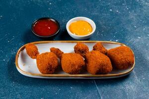 Deep fried Chicken Lolipop or Chicken drumstick with tomato sauce and mayo dip served in a dish isolated on background side view photo