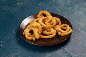 indian sweets deep fired jalebi, jilipi, jilabi served in a dish isolated on background top view photo