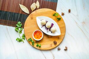 Deep-fried Fish Ball with chili sauce served in dish isolated on wooden board top view on marble background hong kong food photo