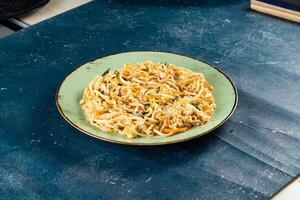 Traditional Spicy chow mein in a bowl isolated on marble background top view of chinese noodles photo