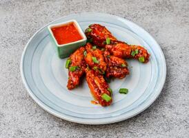 spicy honey wings with chilli sauce served in dish isolated on background top view of asian food photo