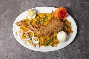 Chicken Bhuna Khichuri biryani white rice pulao with boiled egg and fried onion served in dish isolated on background top view of bangladesh food photo
