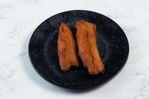 deep fried brinjal pakora or beguni served in a dish isolated on background top view of Indian and bengali food photo