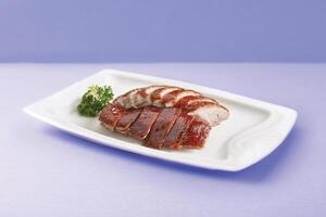 Crispy Roasted Irish Fat Duck Served in a dish isolated on wooden board side view on grey background photo