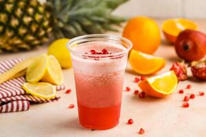 Cinderella Cocktail include orange, pineapple, lemon and pomegranate seeds with raw fruit slice served in glass isolated on table top view of healthy morning drink photo