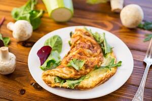 cooked fried omelets with zucchini and herbs photo